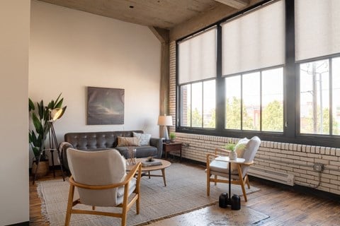 a living room with large windows and a brick wall at The Draper, Missouri